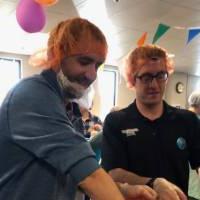 Two alumni sort bags of food together at Kids' Food Basket